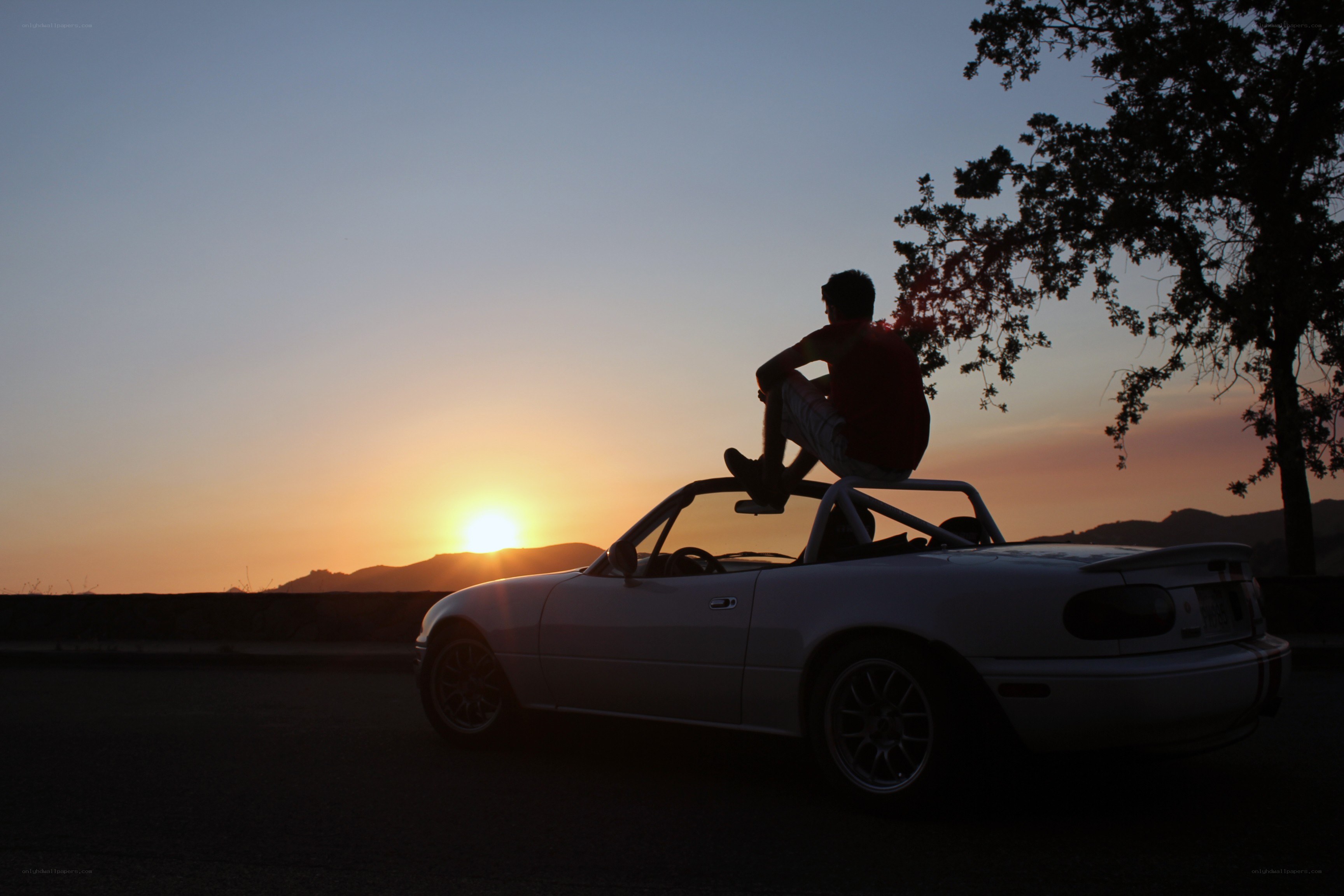 Person on car at sunset