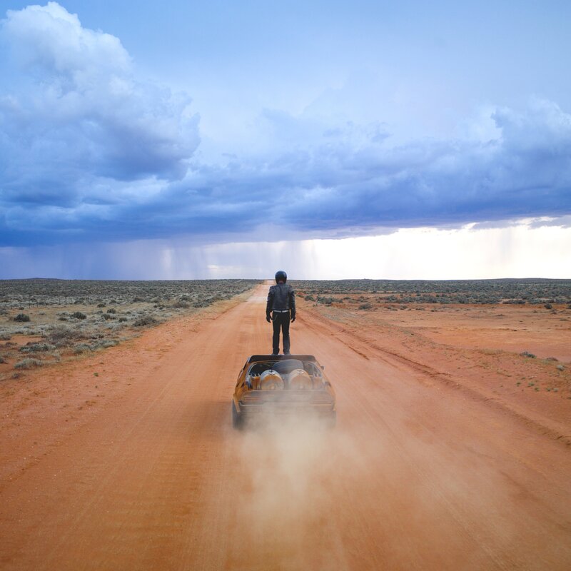 Person on car in desert storm