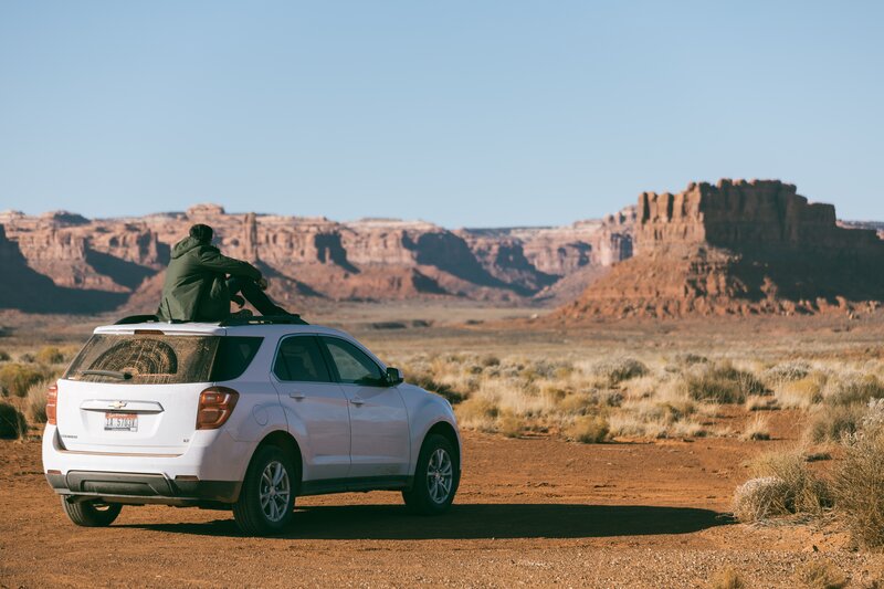 Person on car roof in desert