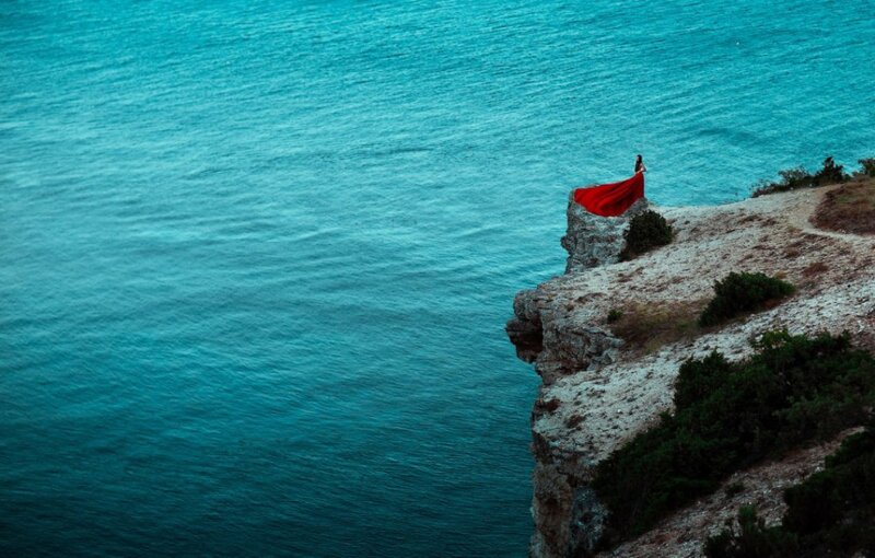 Person on Cliff Edge — Blue, Dramatic, Photograph