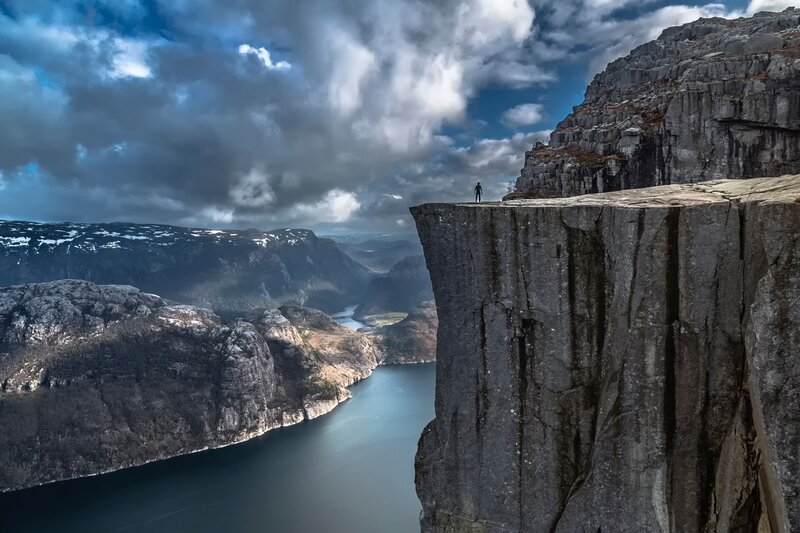 Person on Cliff Edge — Gray, Dramatic, Afternoon, Photograph, Fjord, Clouds