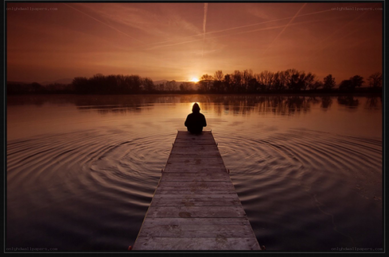 Person on dock at sunset