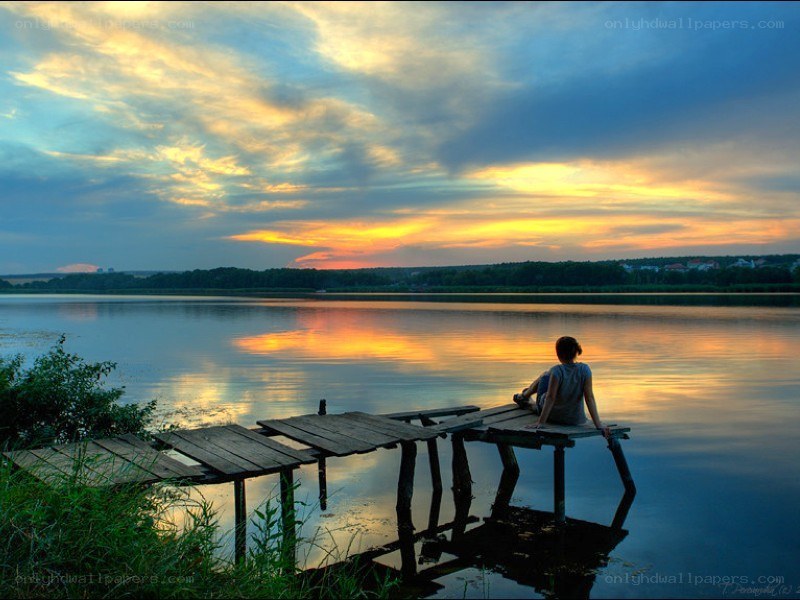 Person on dock at sunset