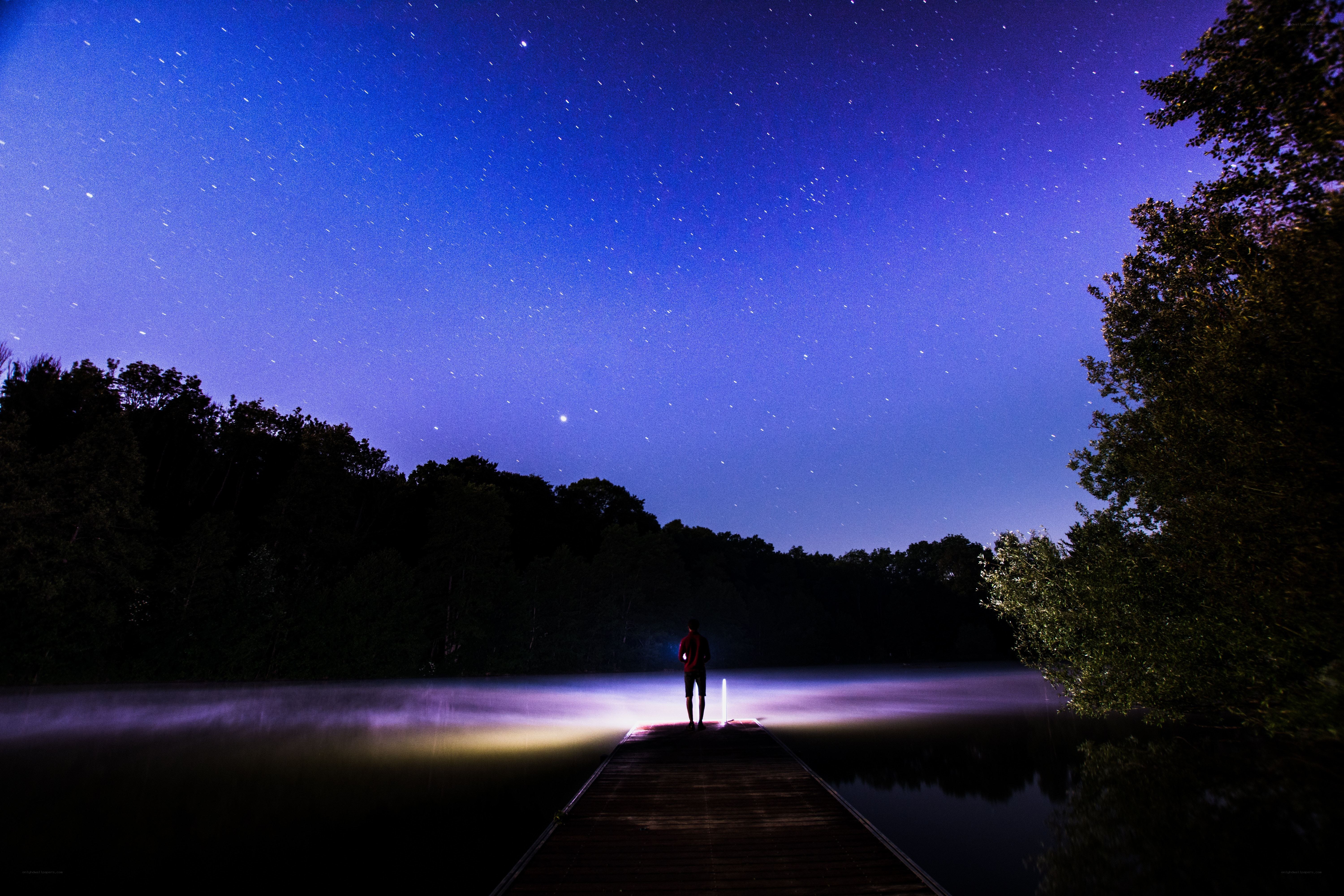Person on dock under starry sky