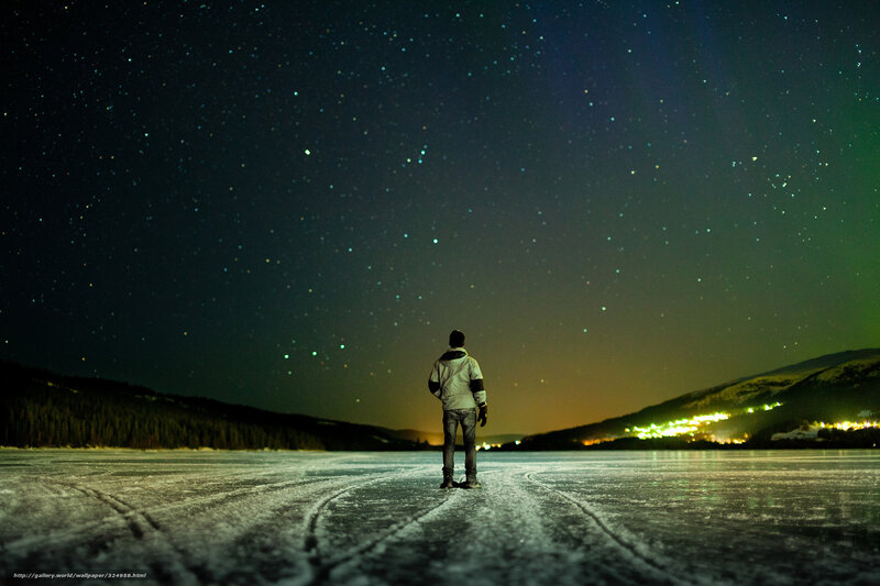Person on frozen lake under stars
