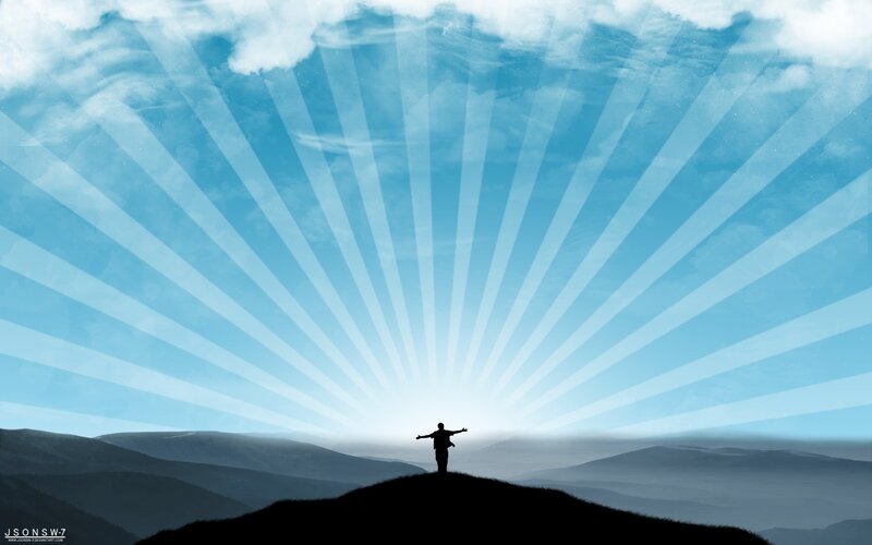 person on hill with sun rays