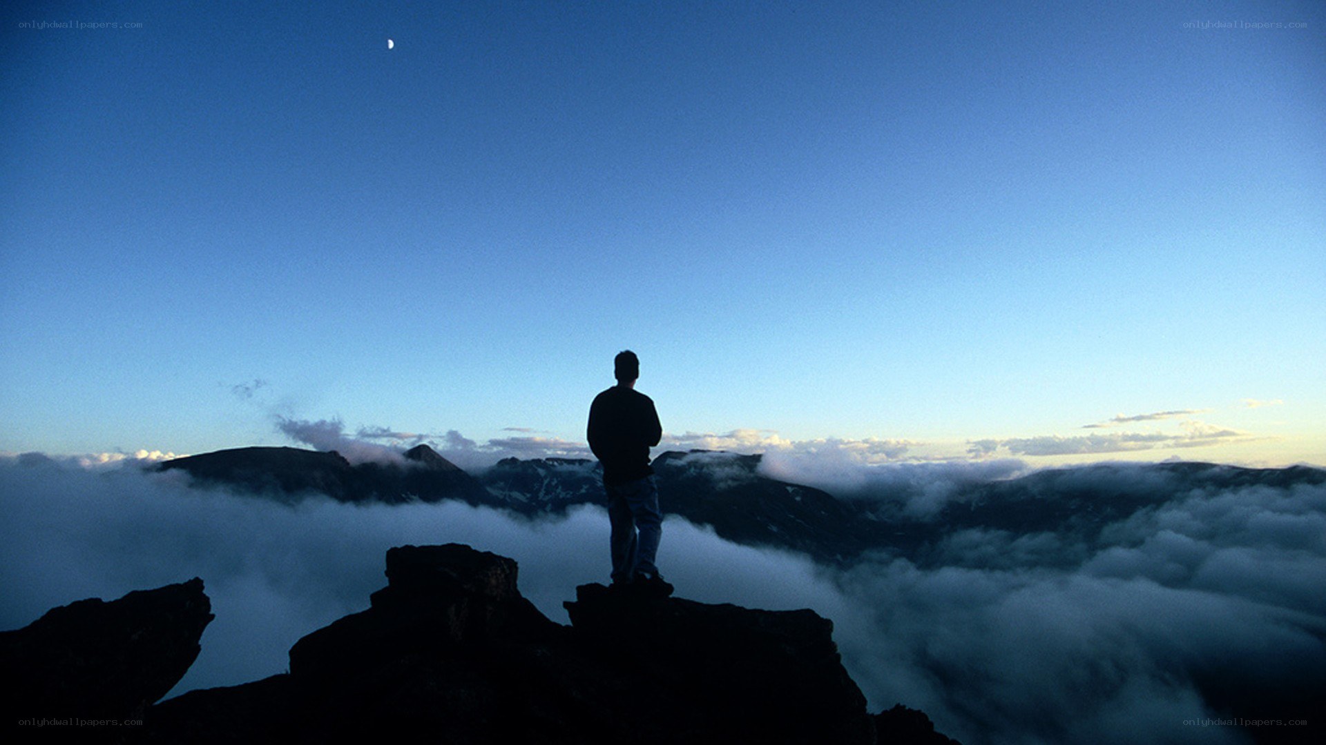 Person on mountain peak at dawn