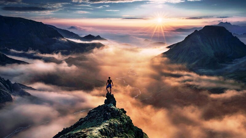 Person on Mountain Peak — Orange