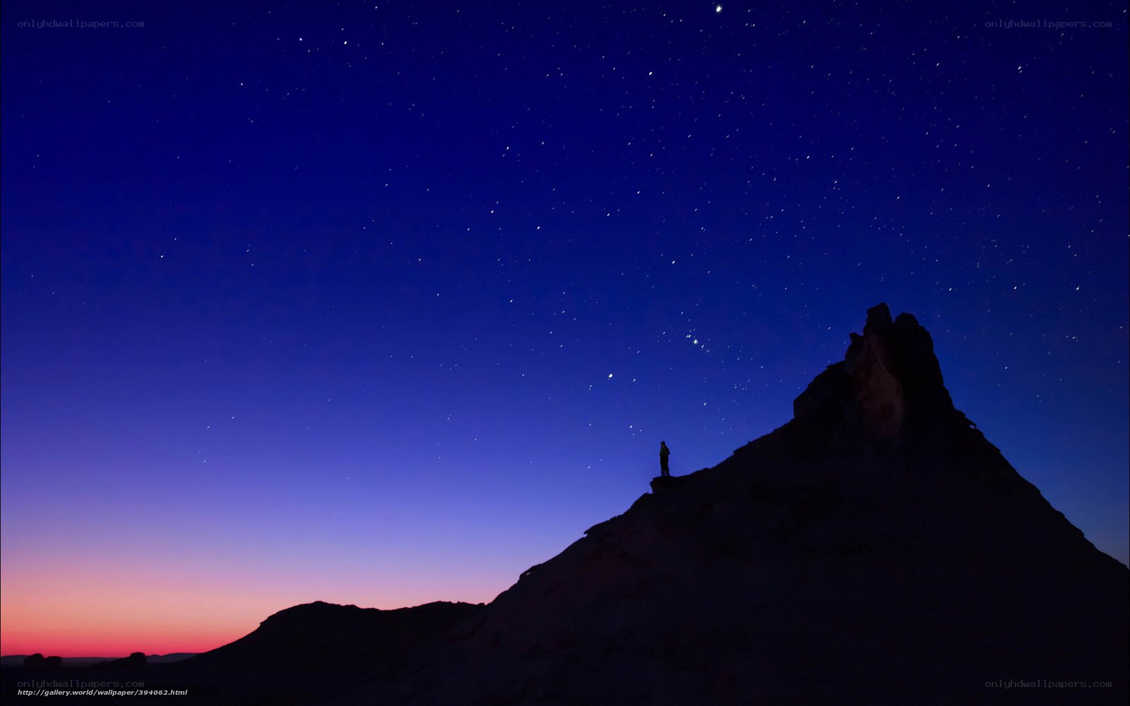 Person on mountain under stars