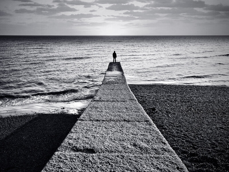 Person on pier at sea