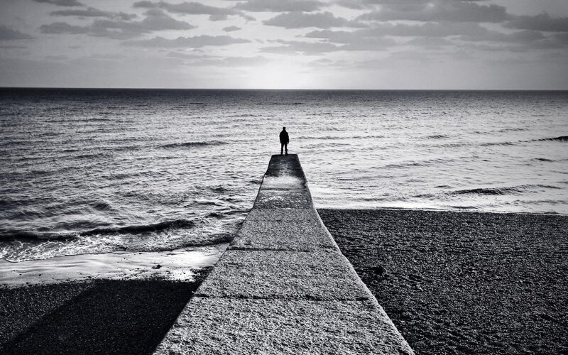 Person on pier at sea