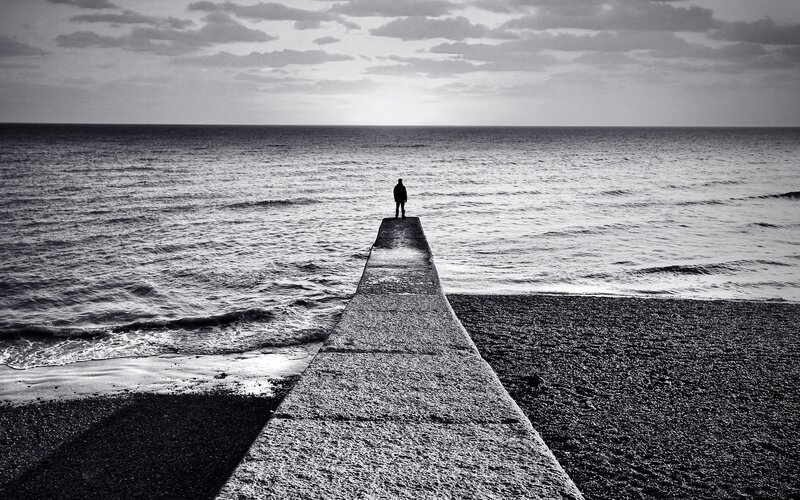 Person on pier at sea