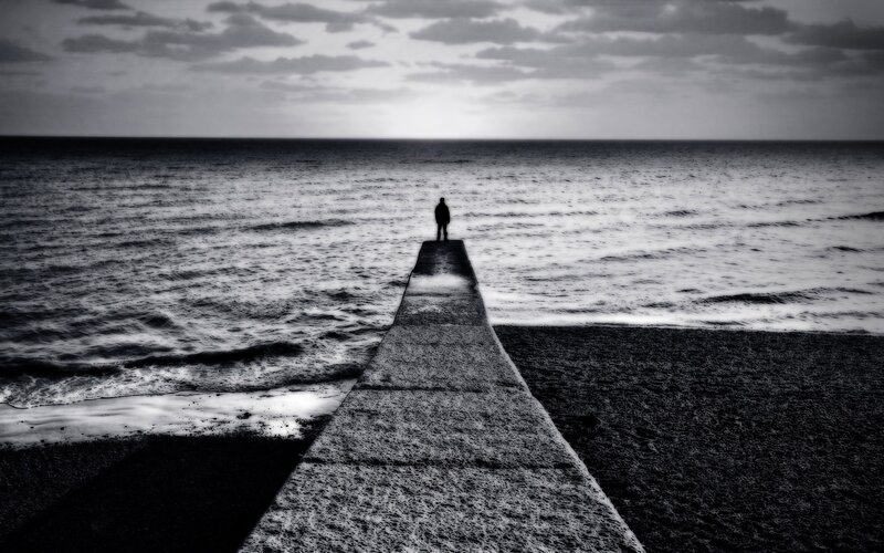 person on pier at sea