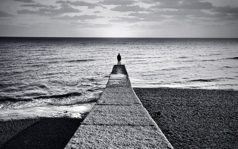 Person on pier at sea