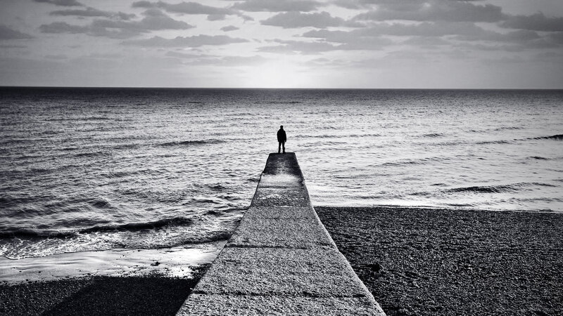 person on pier at sea