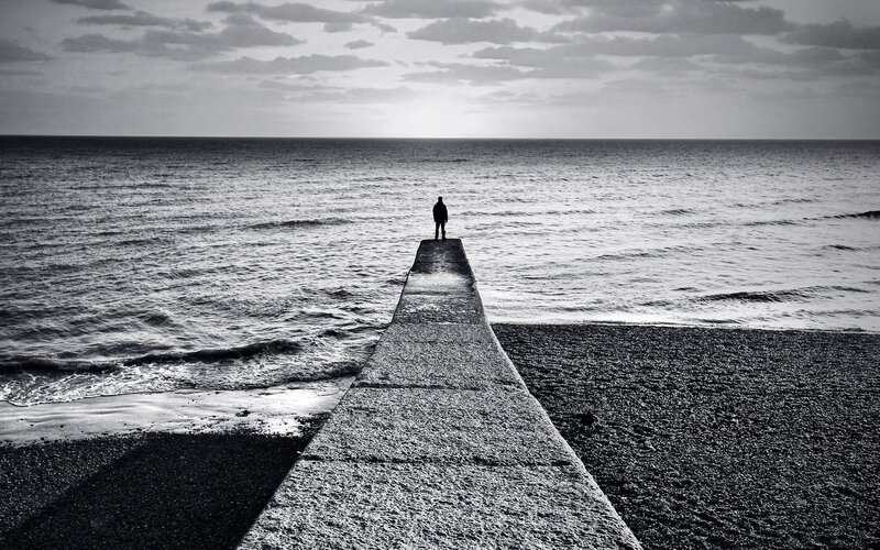Person on pier at sea