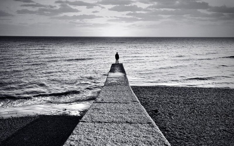 Person on pier at sea