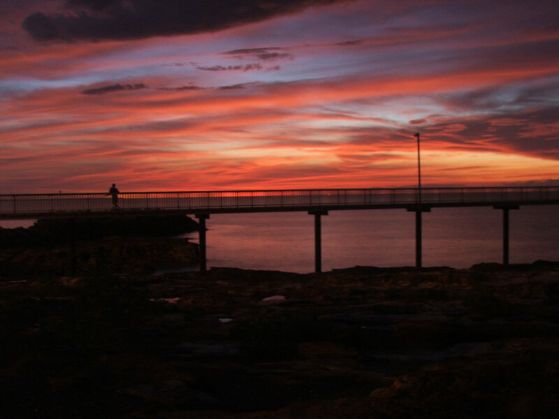 Person on Pier at Sunset — Orange, Dramatic