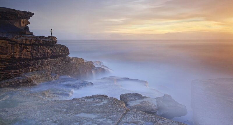 Person on Rocky Cliff — Blue, Serene, Sunset