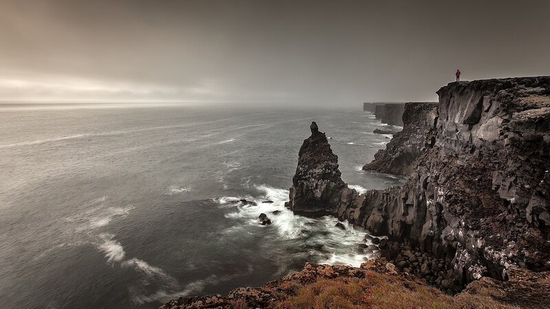 Person on Rocky Cliff — Gray, Dramatic, Photograph