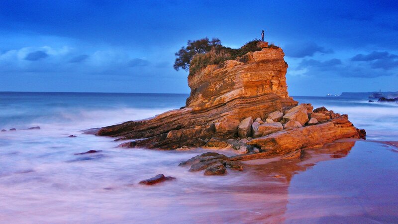 Person on rocky outcrop at dusk