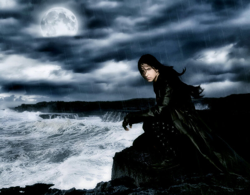 person on rocky shore at night