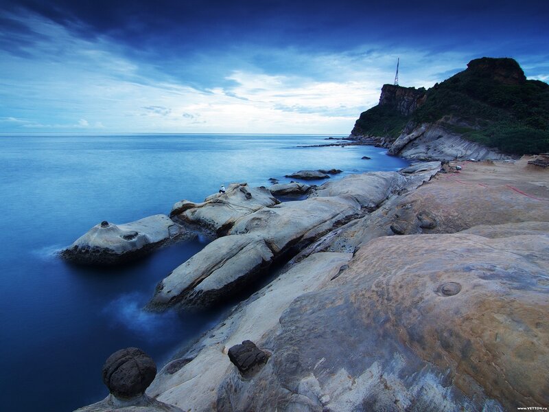 Person on Rocky Shore — Blue, Serene, Sunset, Photograph, Rocks