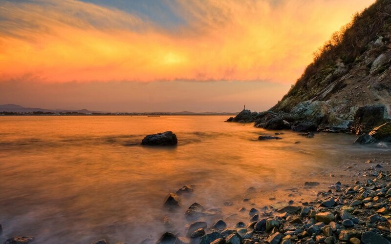 Person on Rocky Shore — Orange