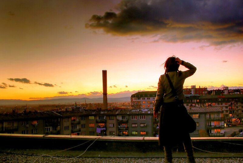 Person on rooftop at sunset