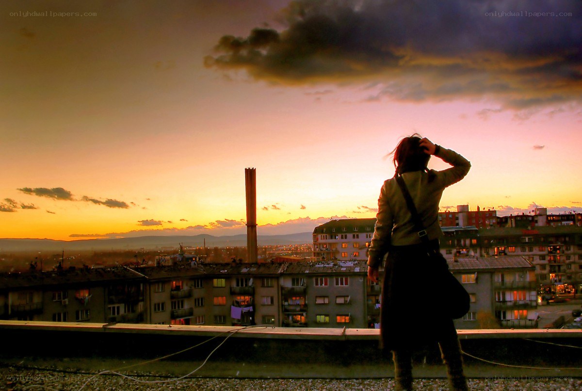 Person on rooftop at sunset