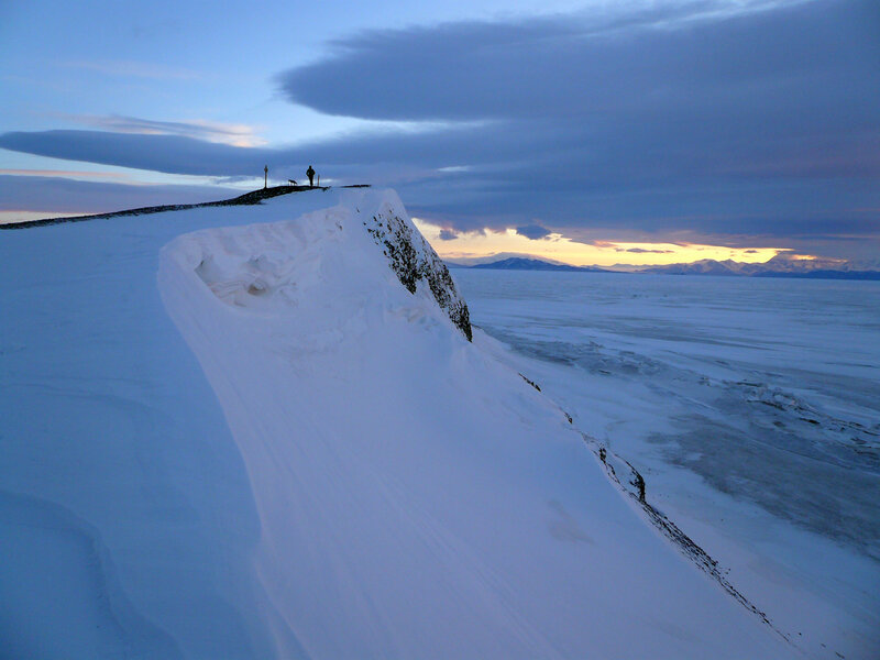 Person on snowy cliff at dusk