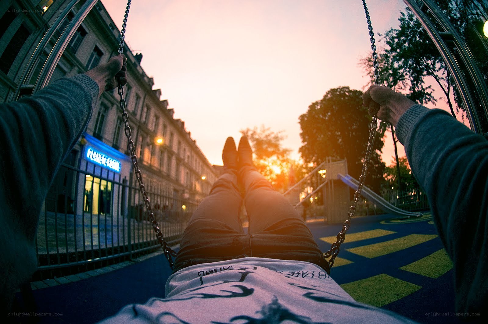 person on swing at sunset