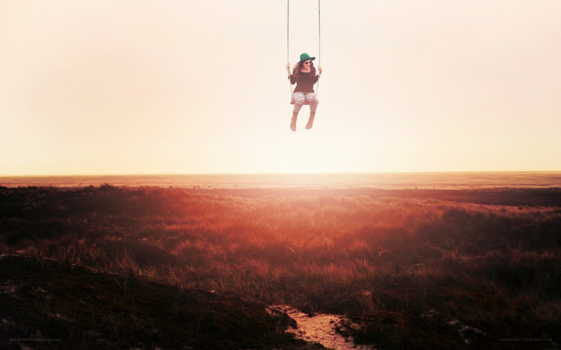 Person on swing at sunset