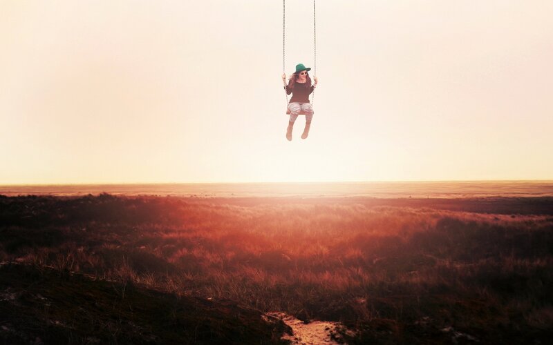 Person on swing at sunset