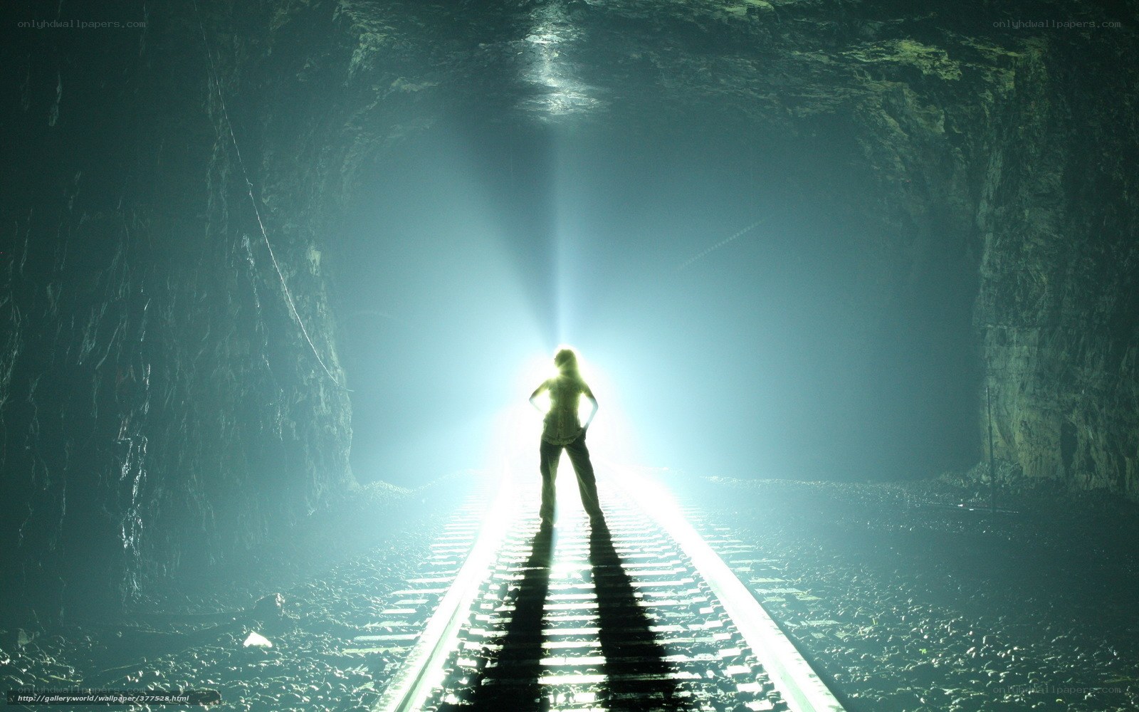 person on train tracks in tunnel