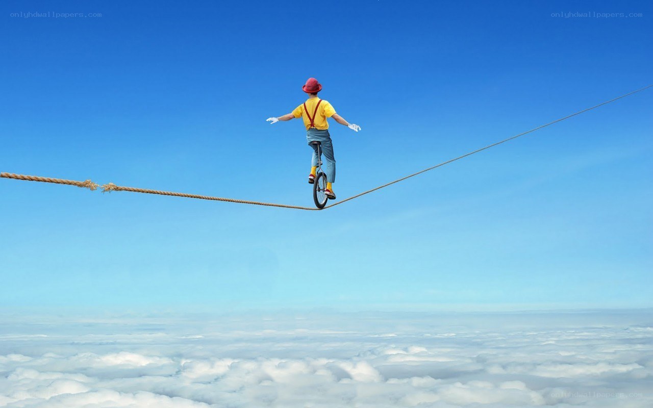 Person on unicycle over clouds