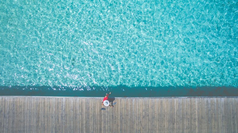 Person on Wooden Pier — Blue, Serene, Afternoon, Photograph