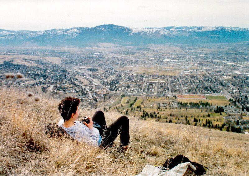 Person overlooking a city from a hill