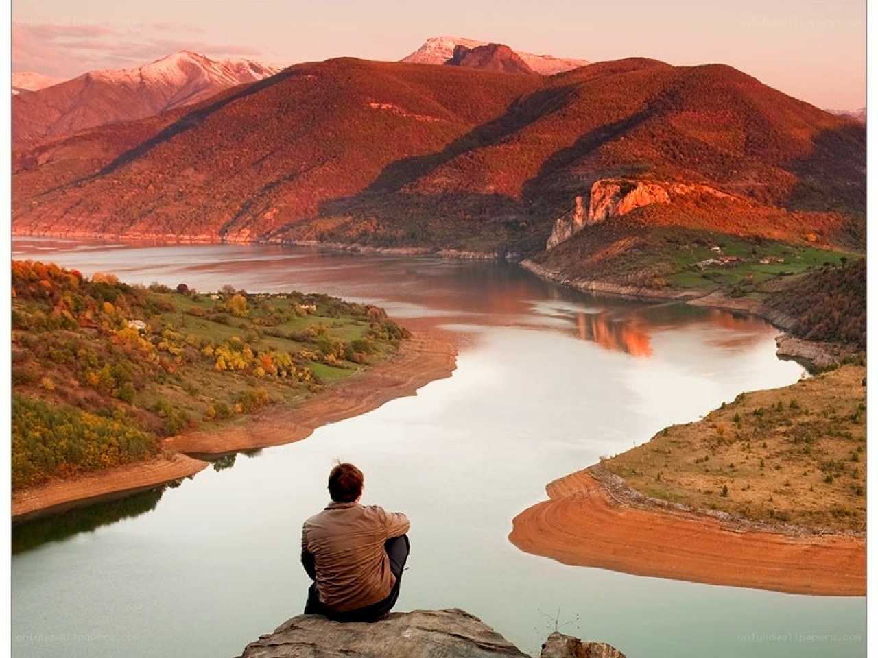 Person overlooking a lake at sunset