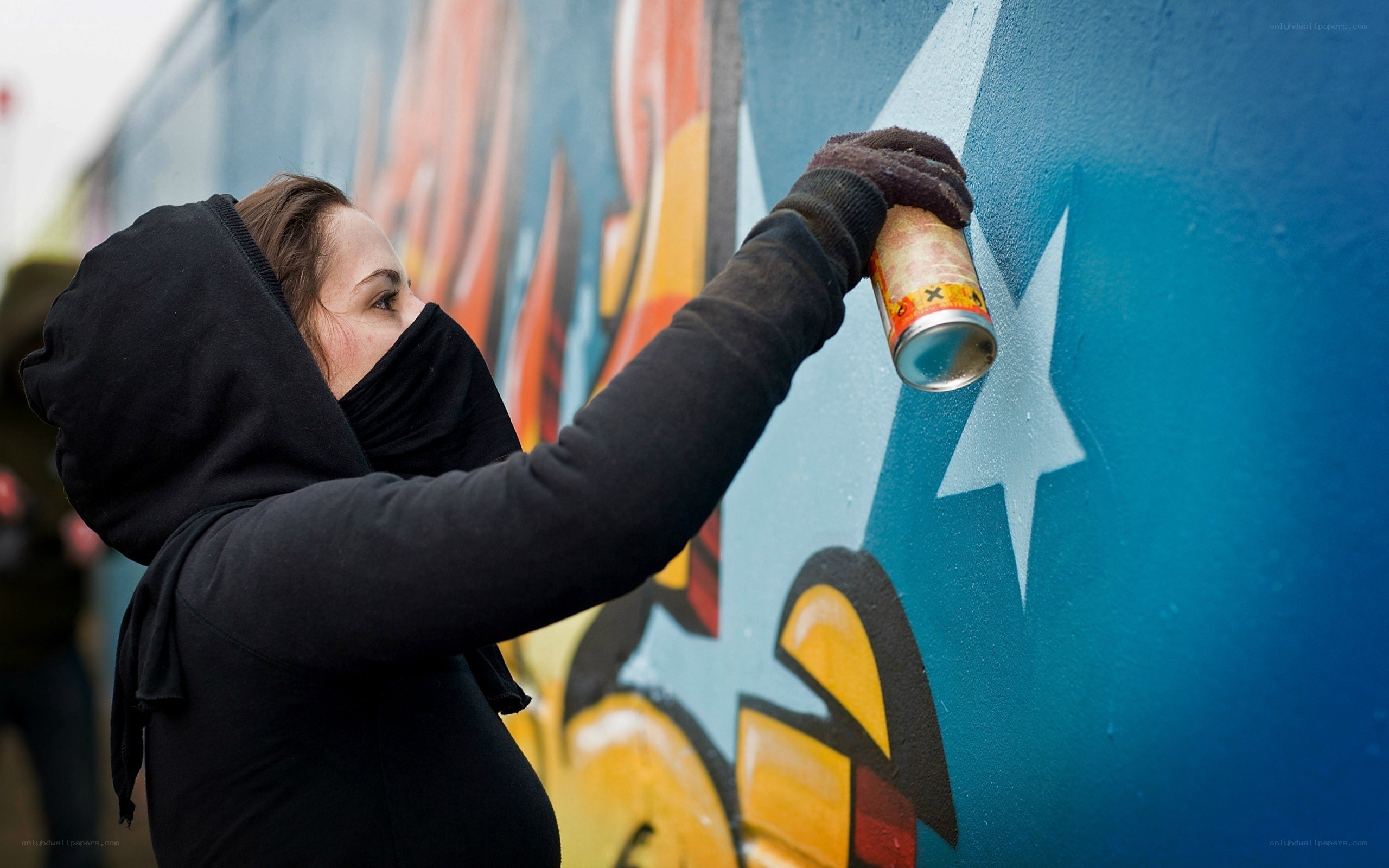 person painting graffiti on wall
