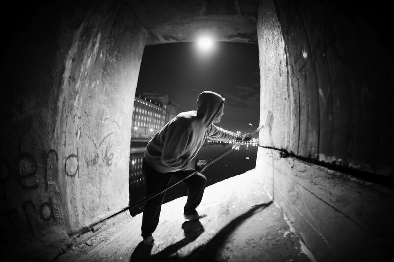 Person painting under a bridge at night