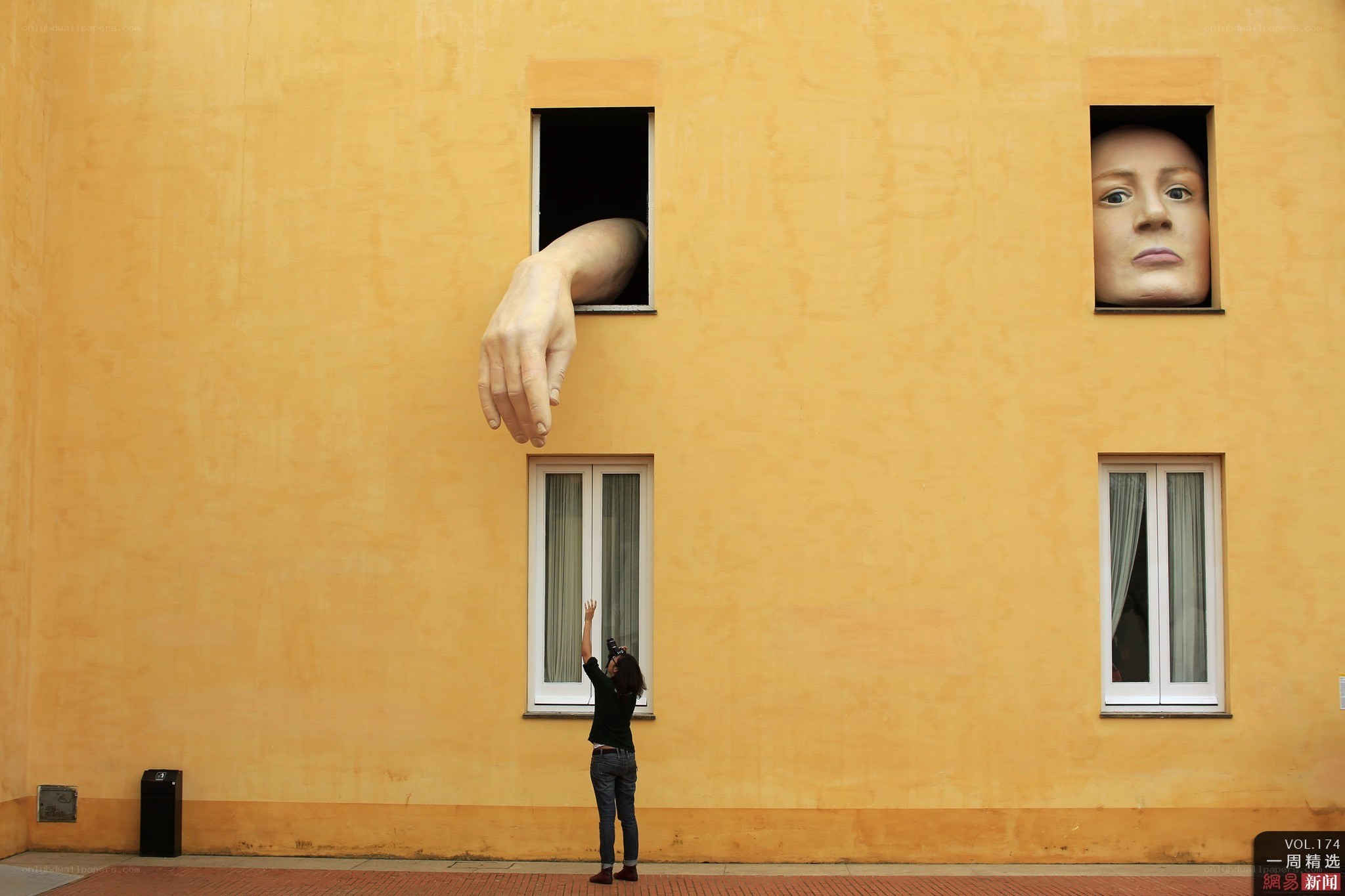Person photographing art installation