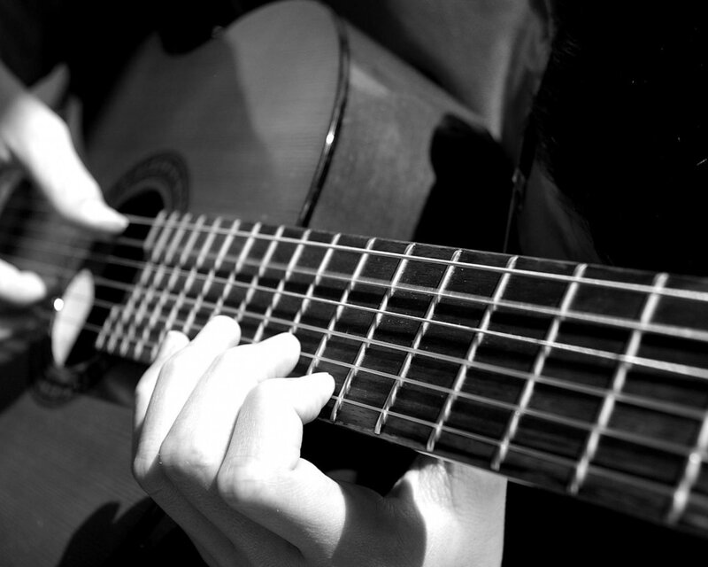 person playing acoustic guitar