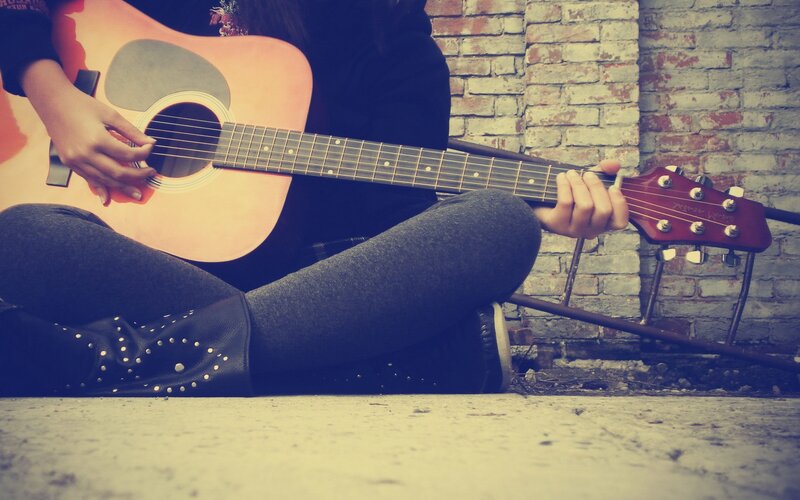 person playing acoustic guitar