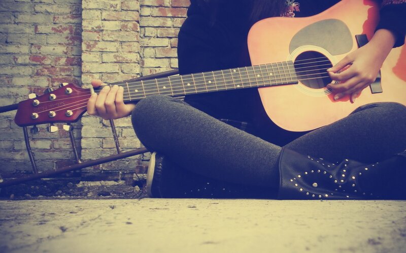 person playing acoustic guitar