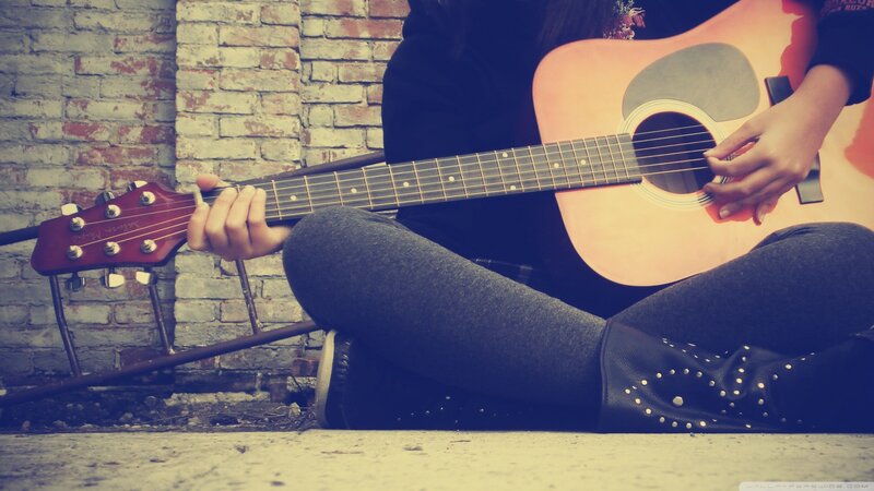 person playing acoustic guitar