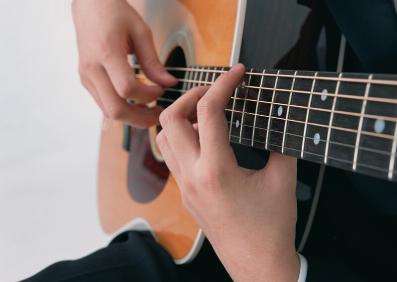 person playing acoustic guitar