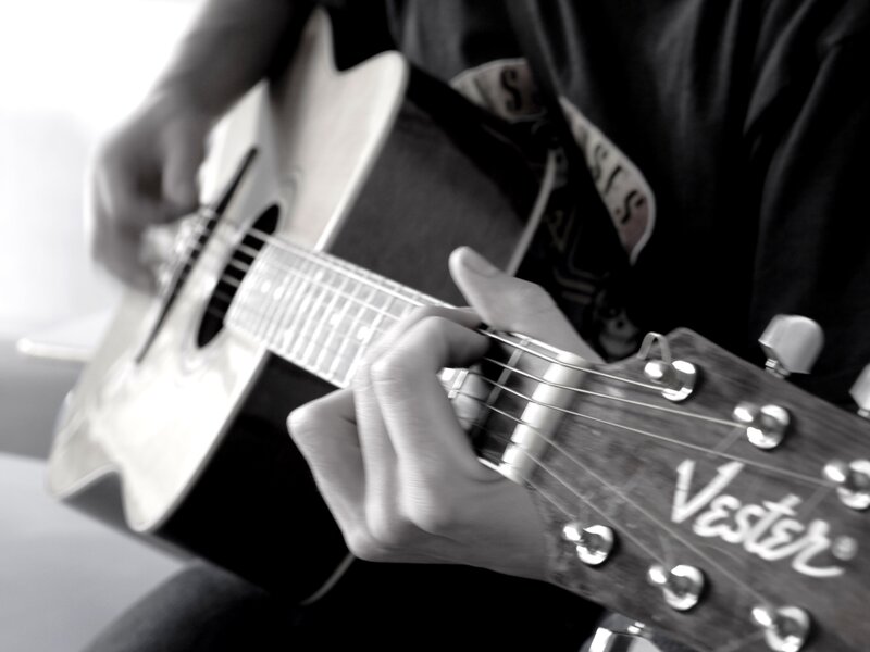 person playing acoustic guitar