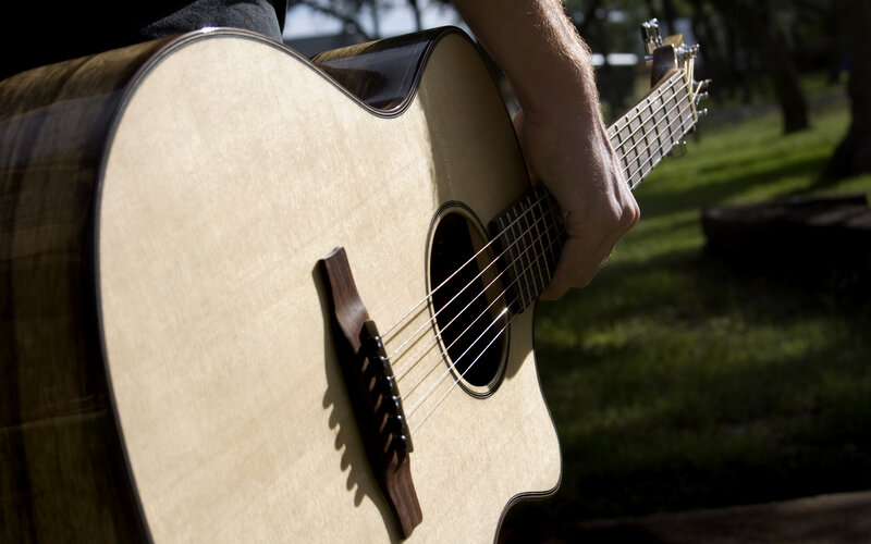 person playing acoustic guitar