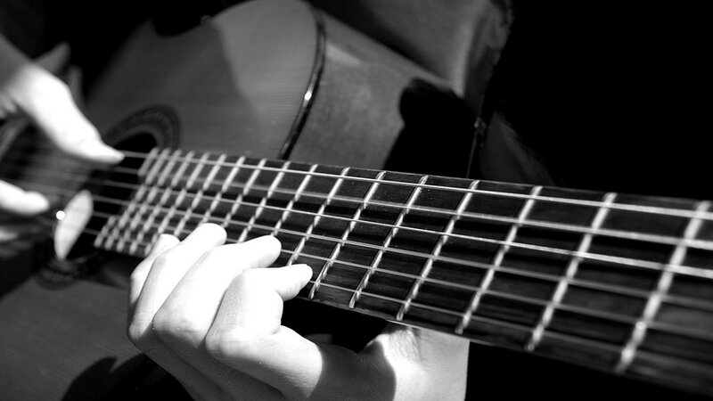 Person Playing Acoustic Guitar — Black, Focused